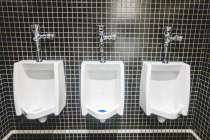 Three White Urinal on Back Tiles Wall